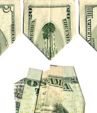 Queste banconote da 5, 20 e 100 dollari, piegate opportunamente, mostrerebbero la distruzione delle Twin Towers; sotto, un biglietto da 1 dollaro piegato per formare la parola OSAMA